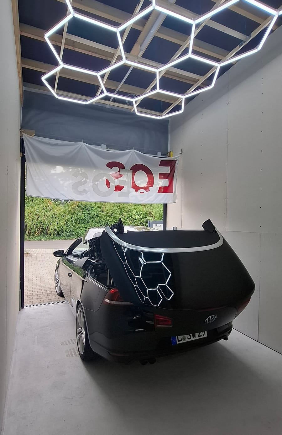 VW EOS mit geöffnetem Verdeck in der Werkstatt der EOS Dachtechnik